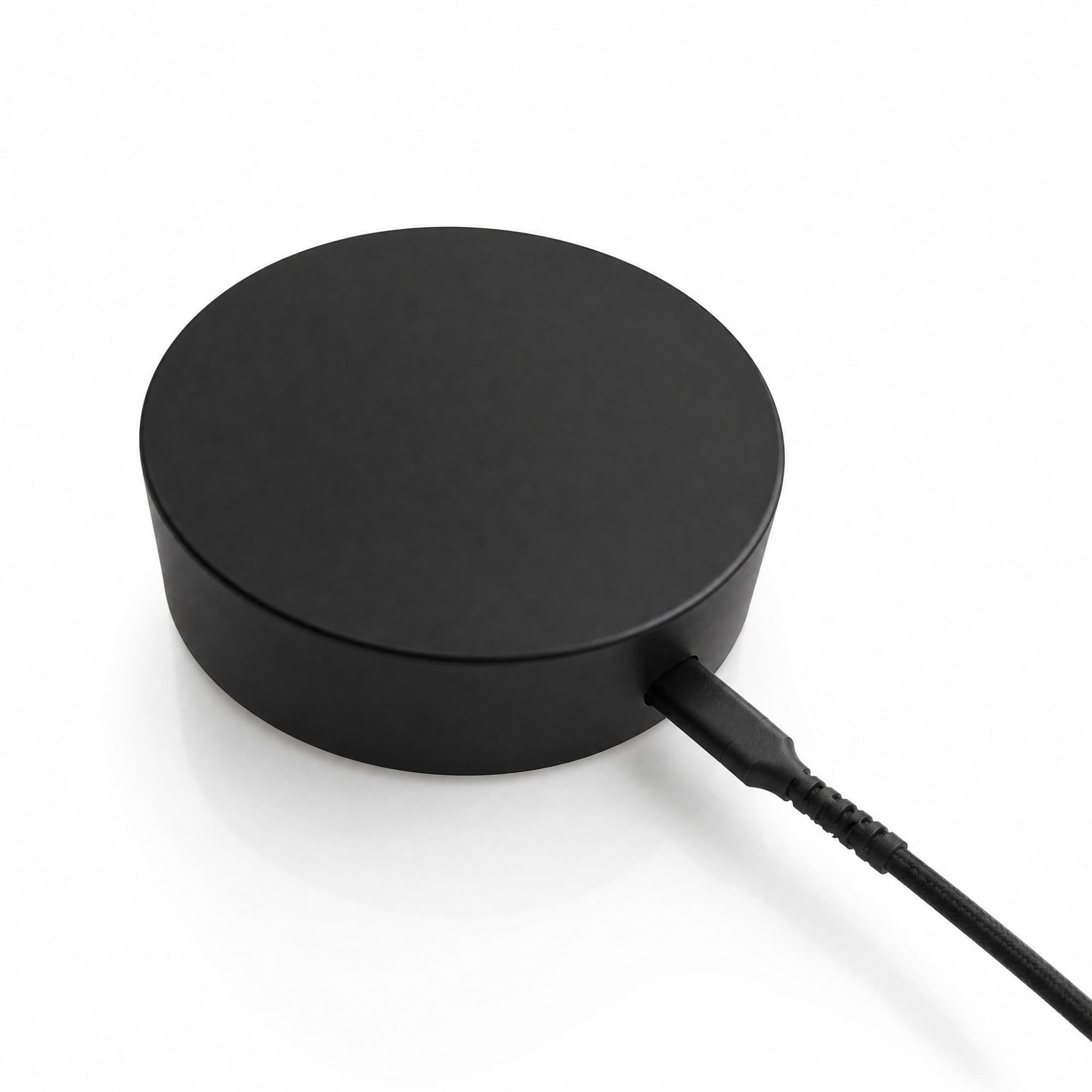 The Dormio sensor, a matte black disc with a braided cable running from its side