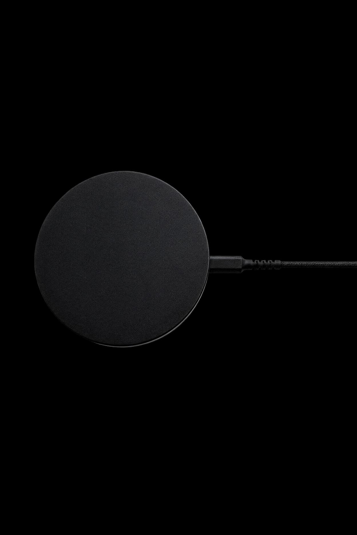 The Dormio sensor, a matte black disc with a braided cable running from its side